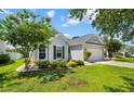 Well-maintained home with beautiful landscaping, lush green lawn, and a two-car attached garage at 3647 Diamond Stars Way, Little River, SC 29566