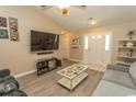 Comfortable living room featuring wood floors, a vaulted ceiling, and a large TV at 3879 Mallard Way, Little River, SC 29566