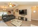 Inviting living room with wood floors, a vaulted ceiling, large TV, and comfortable seating at 3879 Mallard Way, Little River, SC 29566