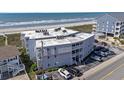 View of multi-story condo building located close to the beach with compact parking and outdoor showers at 5000 N Ocean Blvd. # E-2, North Myrtle Beach, SC 29582