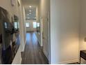 Long hallway featuring wood-look flooring, neutral paint, and ample lighting leading to living spaces at 606 Muster Field Ct., Conway, SC 29526
