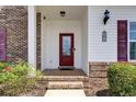 Inviting entryway with a red front door, brick steps, and decorative plants adding curb appeal at 8855 Radcliff Dr. Nw # 50B, Calabash, NC 28467