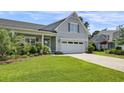 Charming single-Gathering home featuring an attached two-car garage, well-manicured lawn, and inviting curb appeal at 1584 Sand Harbor Cir. # 1584, Ocean Isle Beach, NC 28469