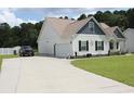 Well-maintained home featuring a spacious driveway, attached garage, and lush green lawn at 242 Four Mile Rd., Conway, SC 29526