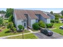 Aerial view of a well-maintained townhome with manicured lawns and ample parking under a clear sky at 4049 Fairway Lakes Dr. # 4049, Myrtle Beach, SC 29577