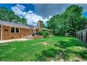 Spacious backyard with lush lawn, brick patio, and privacy provided by mature trees at 4189 Schoolhouse Circle, Little River, SC 29566