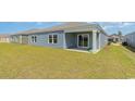 Expansive backyard featuring lush green lawn, complemented by a covered patio and sliding glass doors at 7447 Meadow Walk Loop, Loris, SC 29569