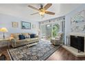 Cozy living room featuring a ceiling fan, plush seating, fireplace, and sliding glass door to the outside at 81 Shadow Moss Pl. # 81, North Myrtle Beach, SC 29582