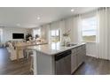 Open-concept kitchen with island, stainless steel appliances, and a view of the dining and living areas at 865 Farmers Passage Loop, Loris, SC 29569