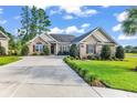 Charming brick home featuring landscaped yard, mature shrubs, and long concrete driveway at 1009 Maccoa Dr., Conway, SC 29526