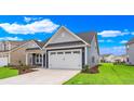 Exterior angle shot featuring a two-car garage, blue siding, white trim, and freshly planted landscaping at 1534 Breakwater Dr., Little River, SC 29566