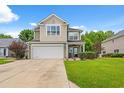 A charming two-story home featuring a large garage, neutral siding, and a covered front porch at 276 Whipple Run Loop, Myrtle Beach, SC 29588