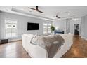 Bright living room with hardwood floors, a modern ceiling fan, and abundant natural light from large windows at 277 Splendor Circle, Murrells Inlet, SC 29576