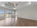 Spacious living room featuring a tray ceiling, ceiling fan, and sliding glass doors to the backyard at 347 Leste Rd., Myrtle Beach, SC 29588