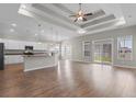 Open concept living room and kitchen area with tray ceiling, modern lighting, and hardwood floors at 347 Leste Rd., Myrtle Beach, SC 29588