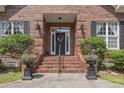 Charming brick front porch with decorative columns, manicured shrubs, and a welcoming front door with wreath detail at 4691 Mill Pond Ct., Murrells Inlet, SC 29576