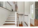 Bright interior shot of an elegant staircase featuring dark wood steps and white banisters at 4986 Salt Creek Ct., North Myrtle Beach, SC 29582