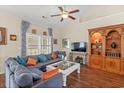 Cozy living room featuring a ceiling fan, hardwood floors, and built-in wooden shelving at 716 Weston Dr., Conway, SC 29526