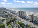 Expansive aerial view of a condo complex, beach and nearby homes at 1003 S Ocean Blvd. # 802, North Myrtle Beach, SC 29582