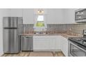 Bright kitchen featuring stainless steel appliances, white cabinetry, and modern countertops at 175 Cypress Ln., Little River, SC 29566