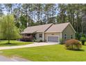 A lovely single-Gathering home features an attached garage, lush lawn, and manicured landscaping at 2135 Starduster Ln., Little River, SC 29566