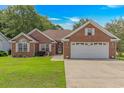 Charming brick home featuring an attached two-car garage and well-manicured lawn at 2454 Glen Dr., Little River, SC 29566