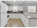 Bright kitchen featuring white cabinets, modern backsplash, and wood-look floors at 300 Kiskadee Loop # K, Conway, SC 29526