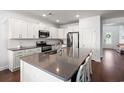 White kitchen featuring a large island with seating, stainless steel appliances and gorgeous countertops at 405 Spring View Ct., Little River, SC 29566