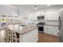 Bright kitchen with white cabinets, stainless steel appliances, and a large island with a sink at 405 Spring View Ct., Little River, SC 29566