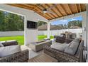 Relaxing covered patio with comfortable seating, a built-in grill, a TV, and a cozy fire pit at 405 Spring View Ct., Little River, SC 29566