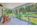 Relaxing front porch with rocking chairs, patriotic flag, and serene outdoor view at 485 Waterford Dr., Georgetown, SC 29440