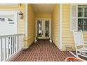 Inviting front porch with brick flooring, decorative statues, and ample space for seating at 492 Grand Cypress Way, Murrells Inlet, SC 29576
