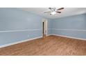 Bright, airy living room featuring light blue walls, wood-look flooring, and a ceiling fan at 5 Dogwood St., Hemingway, SC 29554