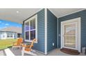 Inviting front porch with comfortable seating and a view of the well-maintained lawn and blue-sided home at 567 Hickman St., Myrtle Beach, SC 29575