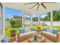 Bright sunroom with wicker furnishings, a ceiling fan, and large windows showcasing a lovely backyard at 708 Alexis Dr., Longs, SC 29568