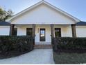 Inviting home facade featuring brick-supported porch, crisp white trim, and well-manicured landscaping at 7610 Driftwood Dr., Myrtle Beach, SC 29572