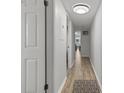 Hallway with white walls, wood floors, and view into the living area at 920 N Waccamaw Dr. # 2310, Murrells Inlet, SC 29576