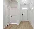 Bright foyer with paneled walls, wood-look floors, and white doors at 964 Irving Dr., Little River, SC 29566