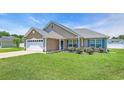 Attractive single-story home with an attached garage, manicured lawn, and charming entryway at 1036 Macala Dr., Conway, SC 29526