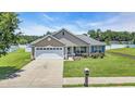 Well-kept one-story house with an attached garage, green lawn, and cozy front porch at 1036 Macala Dr., Conway, SC 29526