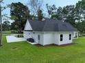 Rear exterior features white siding, dark roof, concrete driveway, and two-car garage, with a grassy yard at 1464 Hawthorn Dr., Pawleys Island, SC 29585