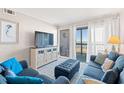 Comfortable living room with balcony access, a mounted TV, and plush seating at 208 N Ocean Blvd. # 226, North Myrtle Beach, SC 29582