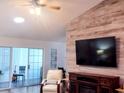 Inviting living room with wood-look accent wall, mounted TV, recliner, and sliding glass doors at 219 Birdie Way, Longs, SC 29568