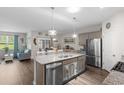 Open-concept kitchen and dining area, featuring a granite island and stainless steel appliances, creating a social atmosphere at 2438 Polaris Path, Myrtle Beach, SC 29577