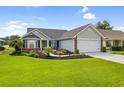 Beautiful single-story home with manicured lawn, lush landscaping and an attached two-car garage at 2783 Sanctuary Blvd., Conway, SC 29526