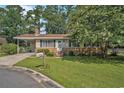 Inviting single-story home with a brick accent, covered carport, and a neatly landscaped front lawn at 424 Villa Woods Dr., Myrtle Beach, SC 29579