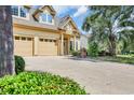 Inviting two-story home boasts a double garage, well-kept lawn, and yellow exterior with a decorative front entrance at 431 Huntington Lake Circle # 80, Pawleys Island, SC 29585