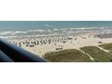 Bustling beach view with people enjoying umbrellas, and boats sailing in the distance at 4800 S Ocean Blvd. # 1008, North Myrtle Beach, SC 29582