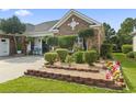 Landscaped front yard with brick borders, decorative shrubbery, and a Maryland state flag at 5904 Bridlewood Rd., North Myrtle Beach, SC 29582