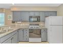 Well-lit kitchen featuring gray cabinets, stainless steel appliances, and granite countertops at 650 Tupelo Ln. # 5-F, Longs, SC 29568